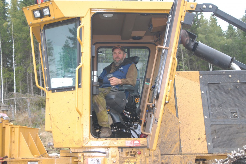 Kurt Collin sits inside the cab of a Tigercat skidder.