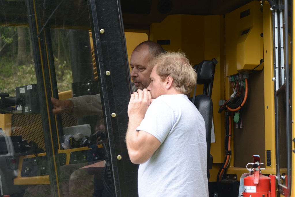 Dave Gentz (frente) conversa con el operador, Bob Morgan, sobre el nuevo harvester de Tigercat.