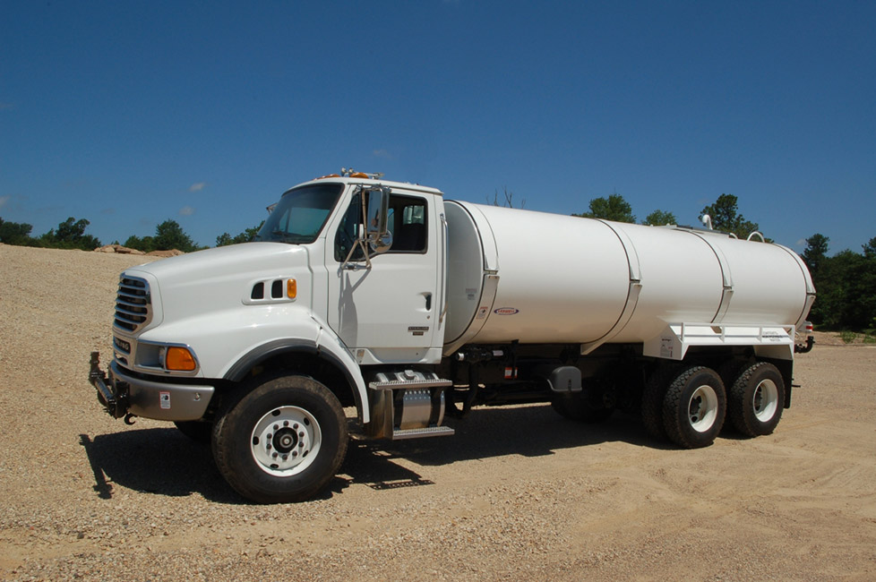 Un camion blanc avec un réservoir d'huile à l'arrière. 