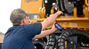 Man greasing a Tigercat machine