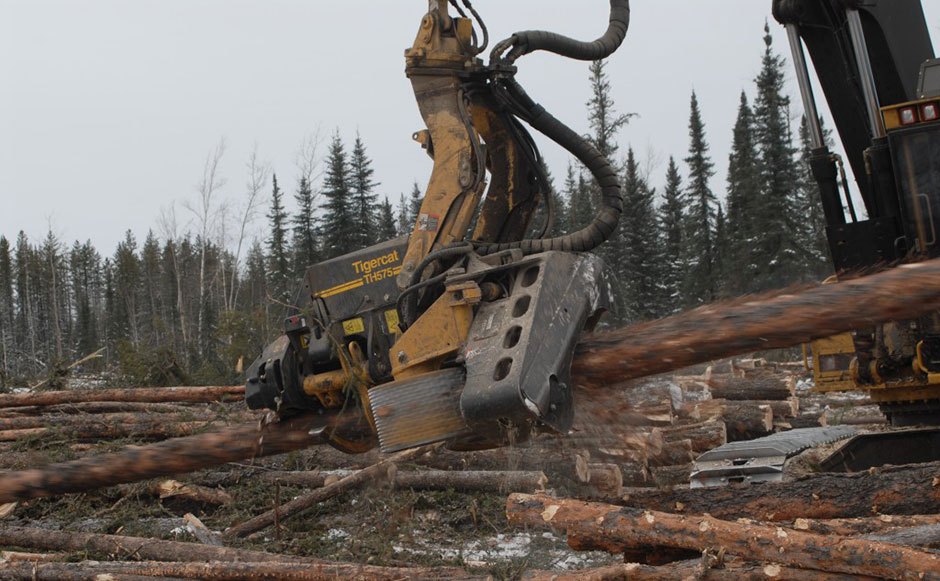 Close up of a Tigercat processing head as a log a log rips through it