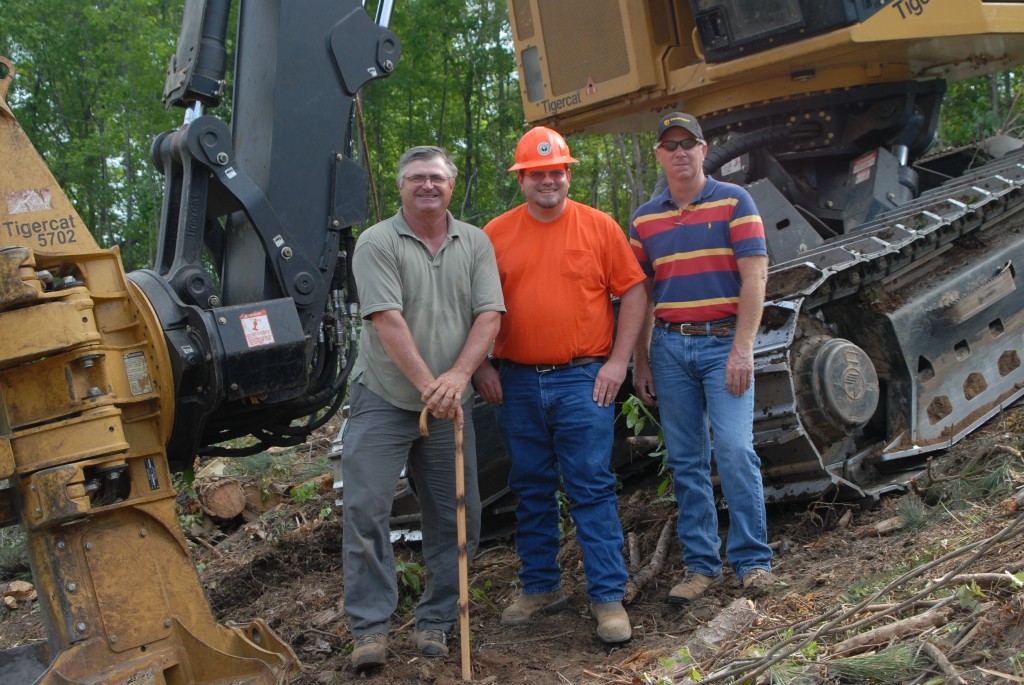One happy operator. Derrick O’Bryant flanked by Tigercat district manager, Johnny Boyd and B&G salesman, Johnny Burton stand together in front of a Feller buncher.