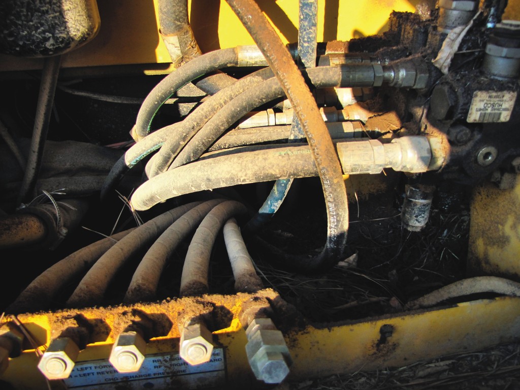 Inspeção de equipamento florestal. Remover detritos perto do coletor do motor e do turbocompressor é fundamental.