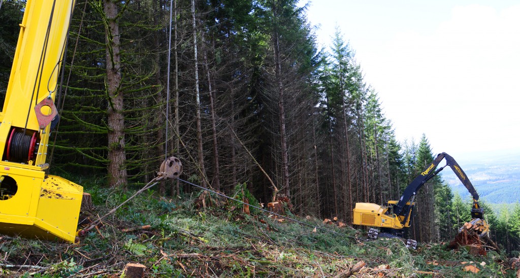 The operator controls the winch as he descends or ascends the slope, preventing sliding and allowing for downhill felling.