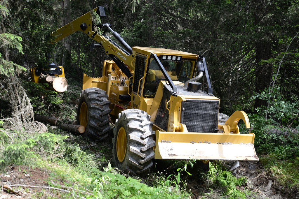  A crane equipped DW610E skidder emerges from the forest with a grapple full of wood. 