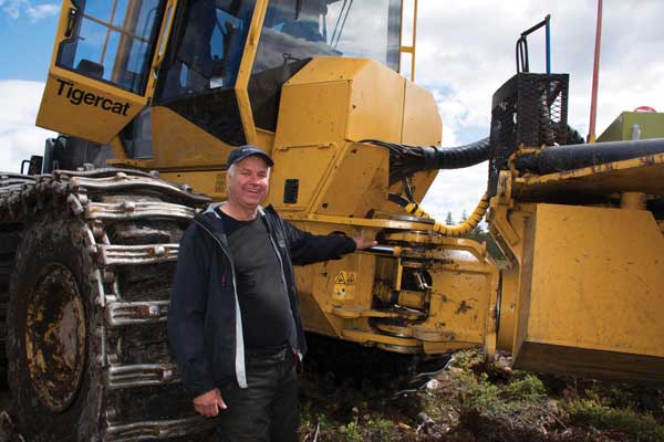 Jaj Johansson står i mittsektionen på en Tigercat-maskin.