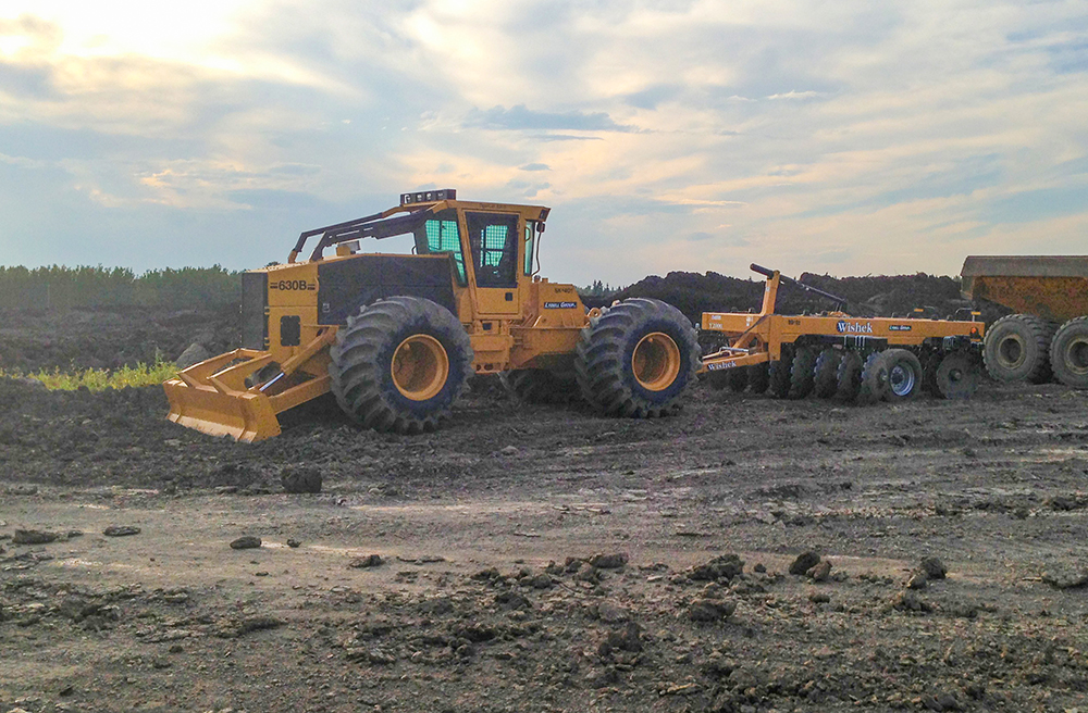 O skidder 630B de Dwayne equipado com uma grade de discos para um projeto de desenvolvimento comercial, a aproximadamente 140 km a sudoeste de Edmonton, em Drayton Valley, Alberta.