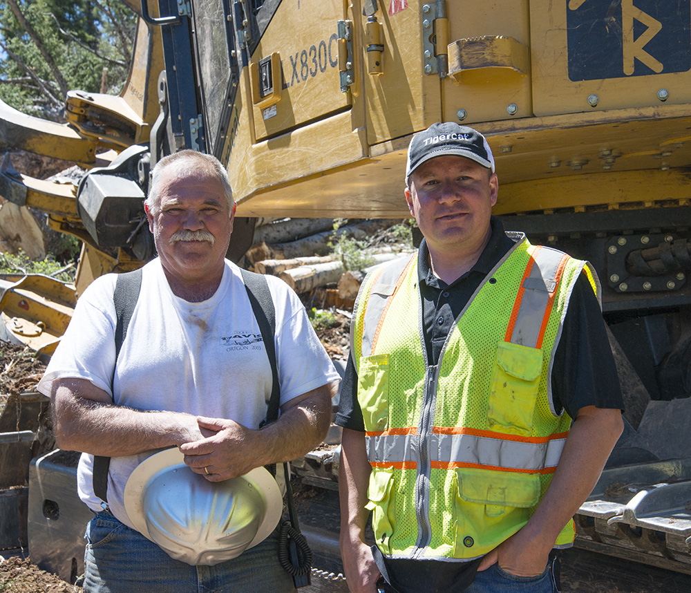 Contract faller Terry Roseberry in front of his Tigercat LX830C with Tigercat district manager, James Farquhar.