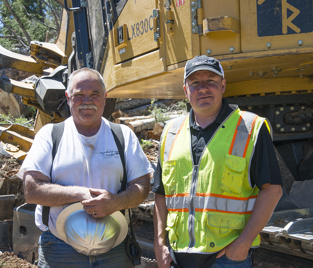 L’abatteur contractuel Terry Roseberry devant son abatteuse-empileuse LX830C, avec James Farquhar, directeur régional de Tigercat.