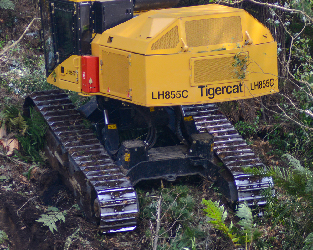 Gros plan sur les chenilles d'une machine LH855C Tigercat sur une pente.