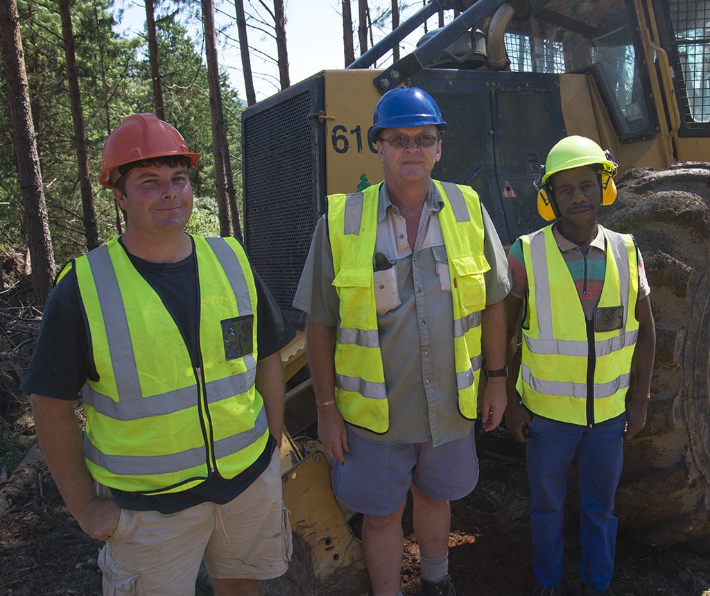 O gerente de operações, Deon Alexander, o proprietário, Grant Rankin, e o operador do skidder 610C, Sipo Madondo.