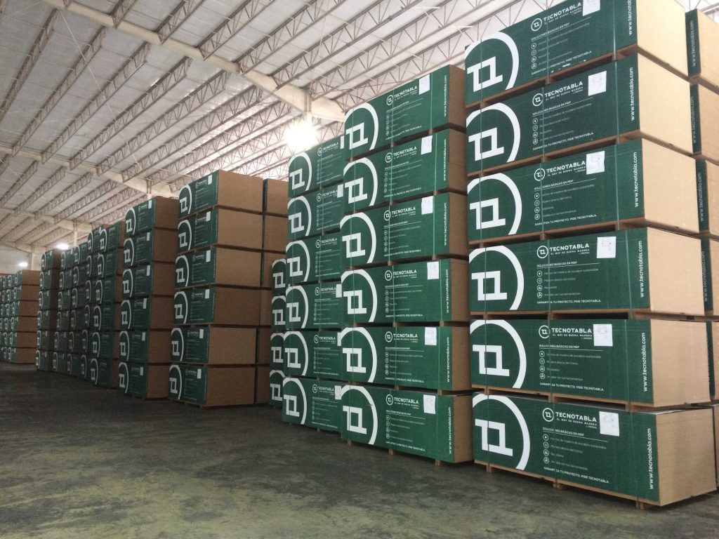 Containers of MDF board stacked in a warehouse as far as you can see.