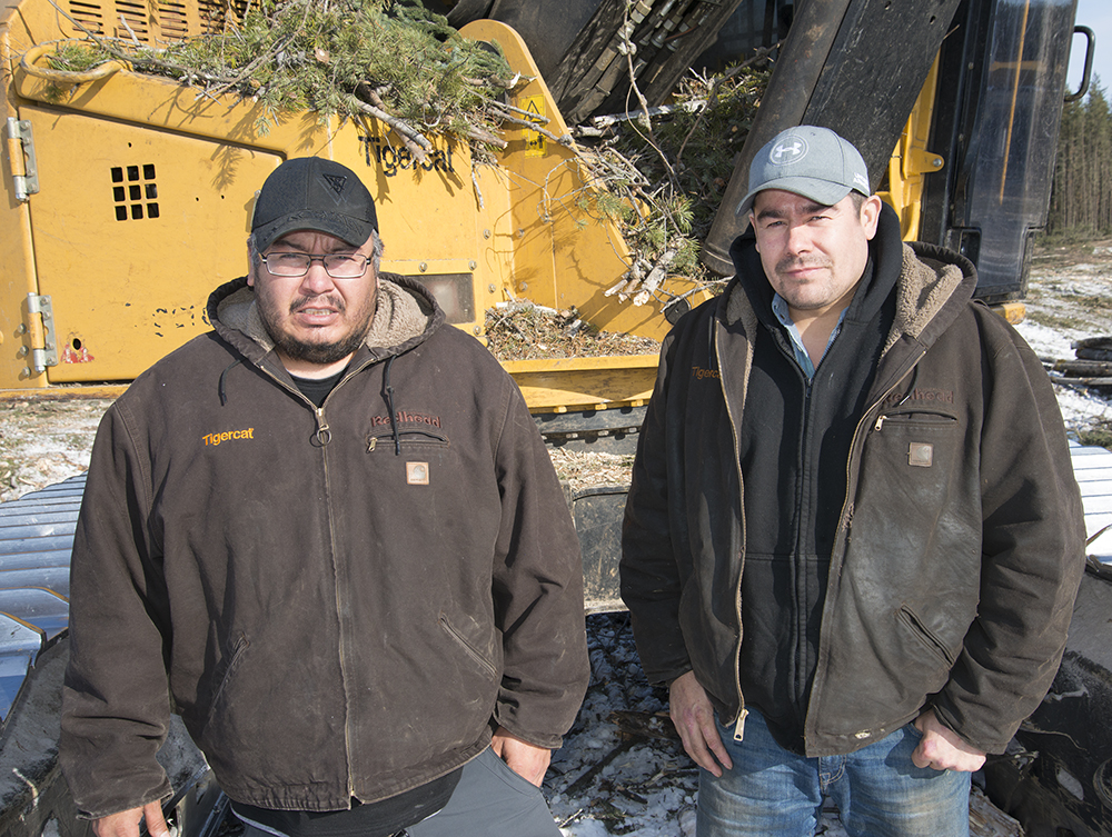 Brothers Darren and Gary Thomas of Thomas Logging Ltd. stand in front of one of their Tigercat Machines