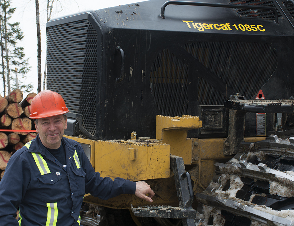 Jocelyn Gagné, da Forestier 2P Logging, na frente de seu novo forwarder Tigercat 1085C.