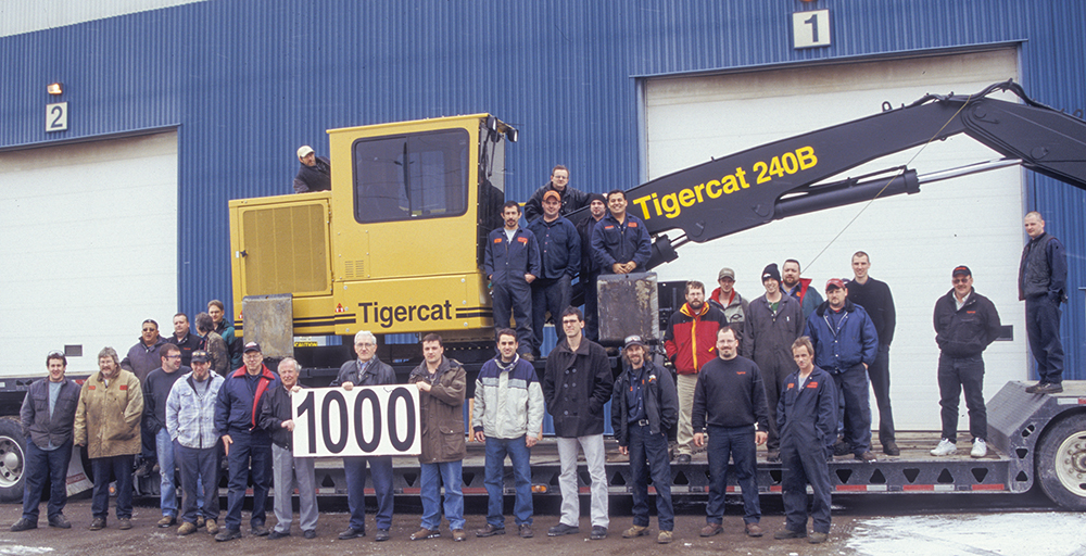 Em apenas cinco anos, a Tigercat entregou sua milésima máquina, em 1997. O grupo de carregadores é mostrado aqui, na frente da primeira fábrica dedicada da Tigercat, no endereço 86 Plant Farm Blvd, Brantford.