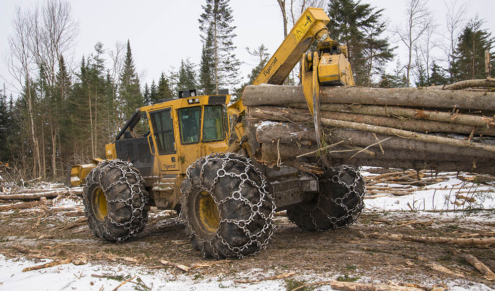 A Tigercat 630E skidder pulling a bundle of wood.