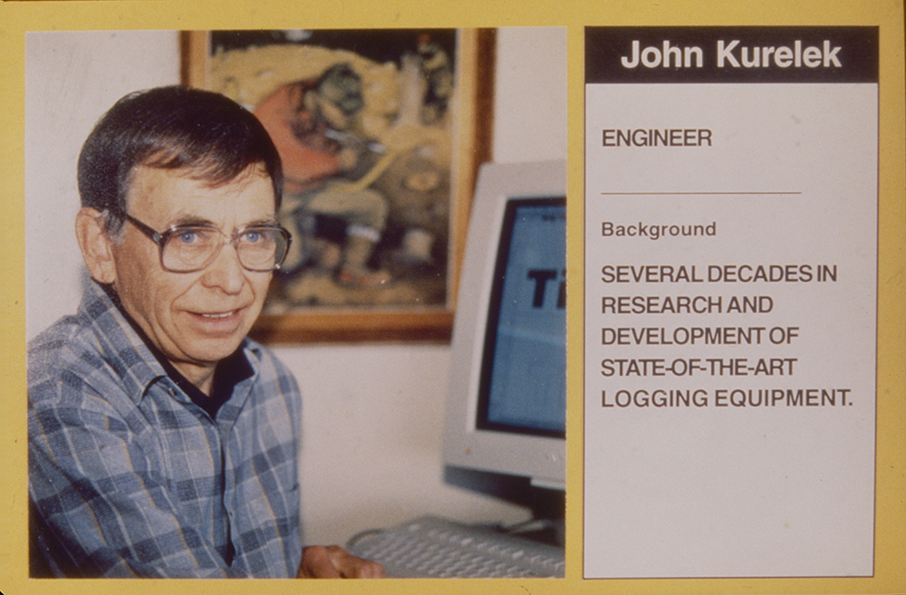 Foto de John Kurelek tomada de una antigua diapositiva de mediados de la década de los noventa. El texto junto a su foto dice: “Ingeniero. Trayectoria: Varias décadas en investigación y desarrollo de equipo para cosecha forestal de vanguardia. 