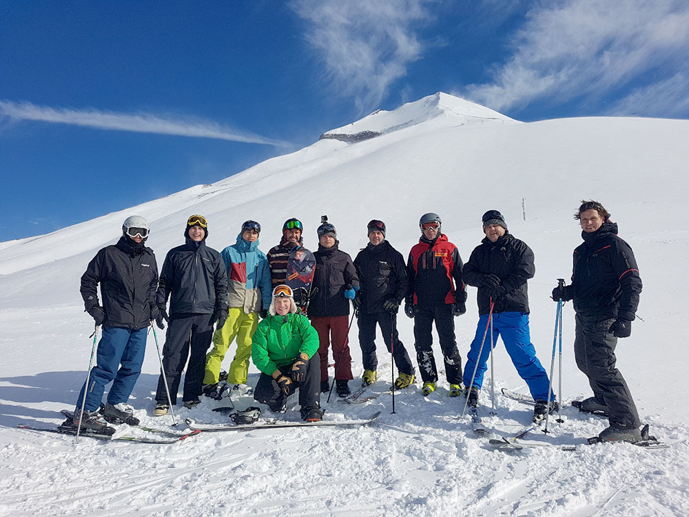 Fin de semana de apreciación del cliente del Latin Equipment Chile; un grupo de personas en un viaje de esquí al pie de una montaña. 