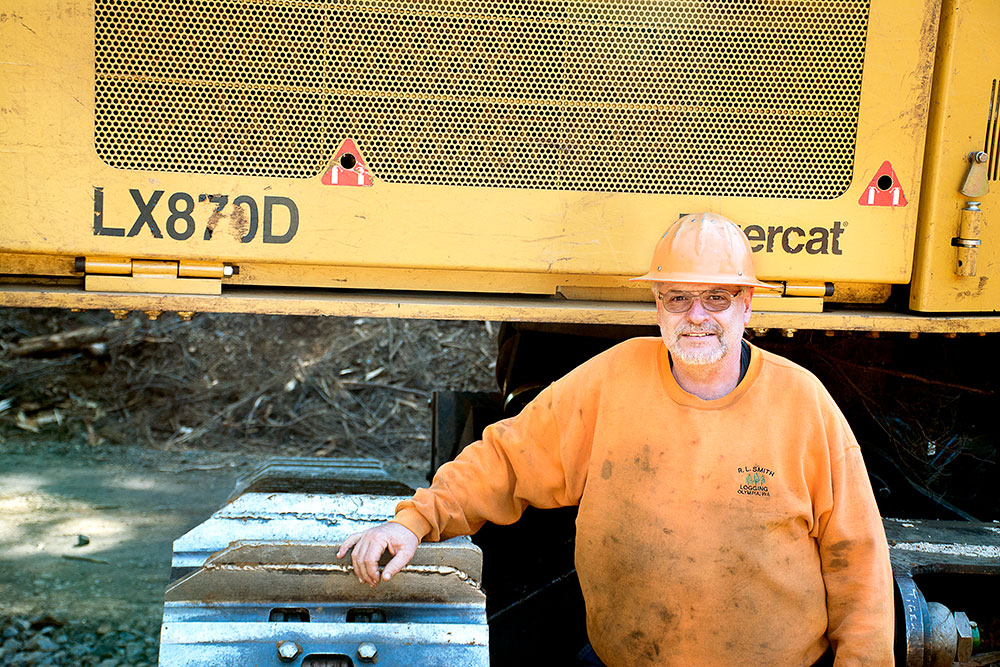 Gary Smith of R.L. Smith Logging in front of his Tigercat LX870D track feller buncher.