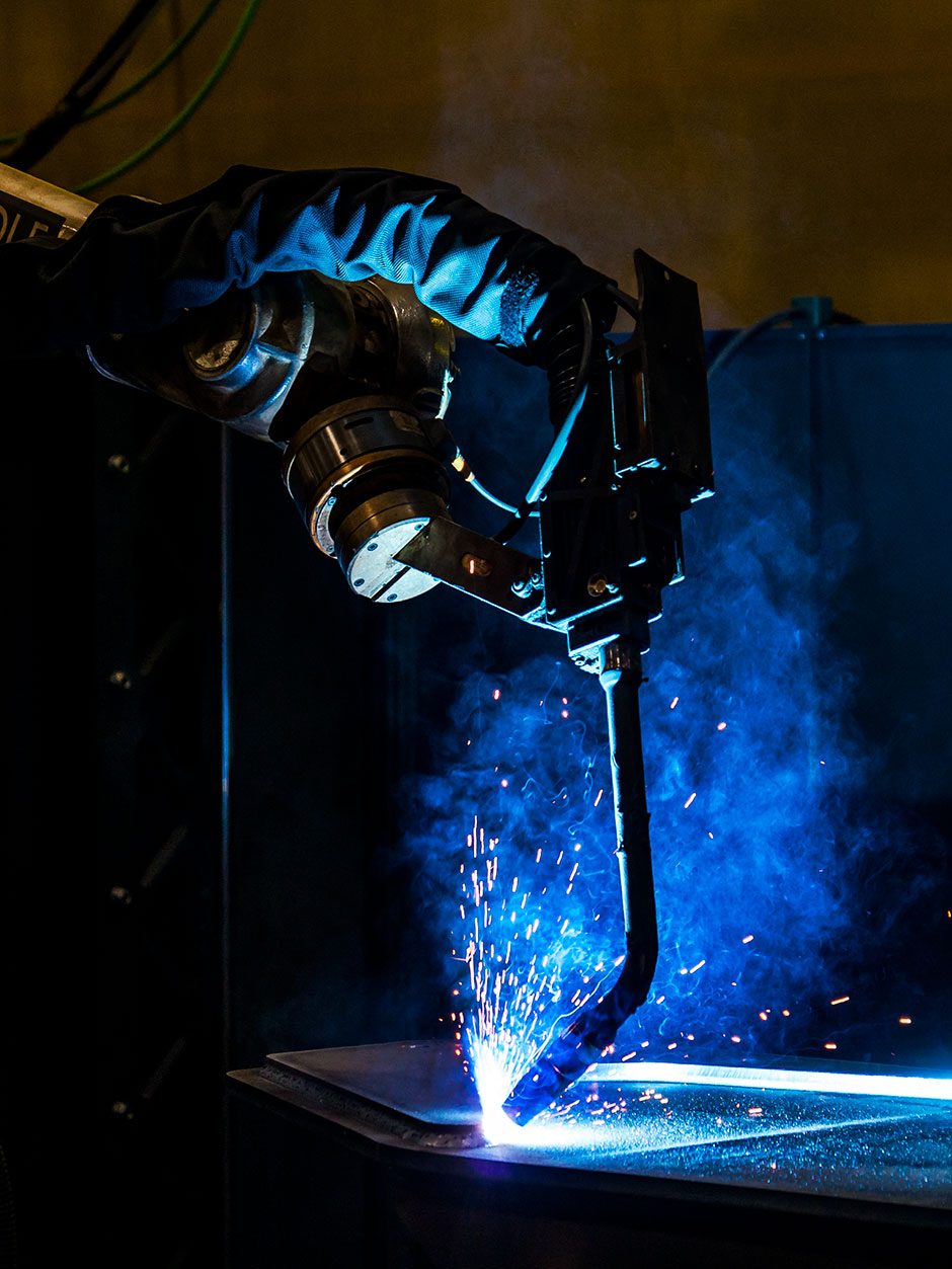 Blue sparks fly as Tigercat's new robotic welding arm, manufactured by Wolf Robotics, welds a part together.