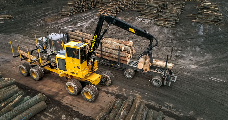 2160 loader forwarder unloading logs from a truck