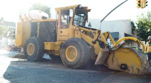 A Tigercat T726G street trencher works at an intersection.