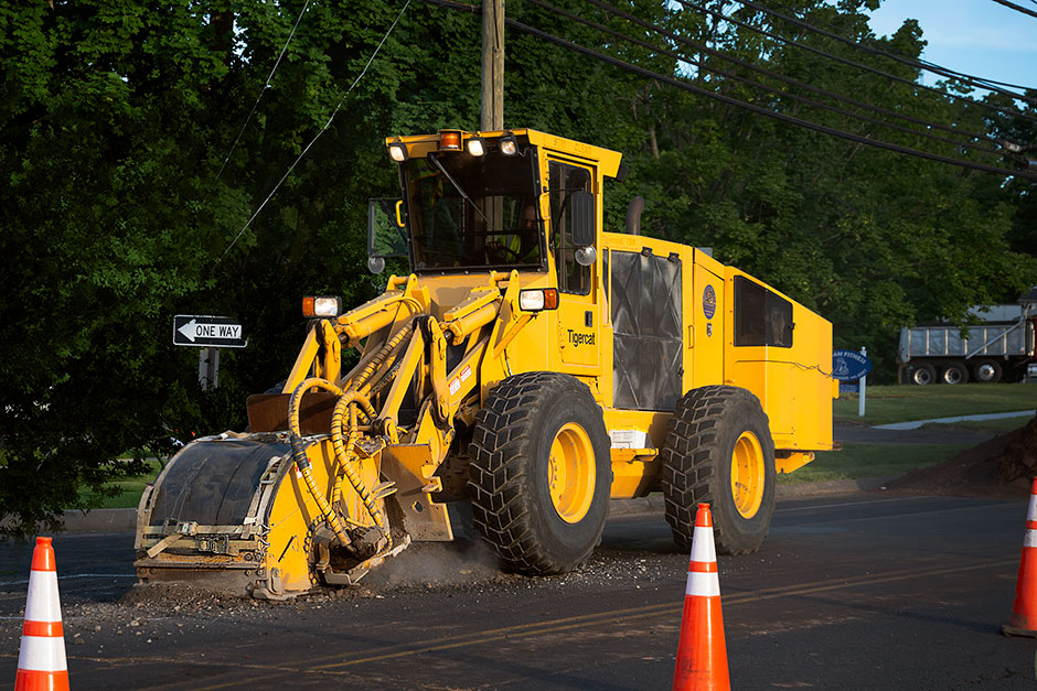 A Tigercat T750 trencher cutting pavement in the middle of a suburb.