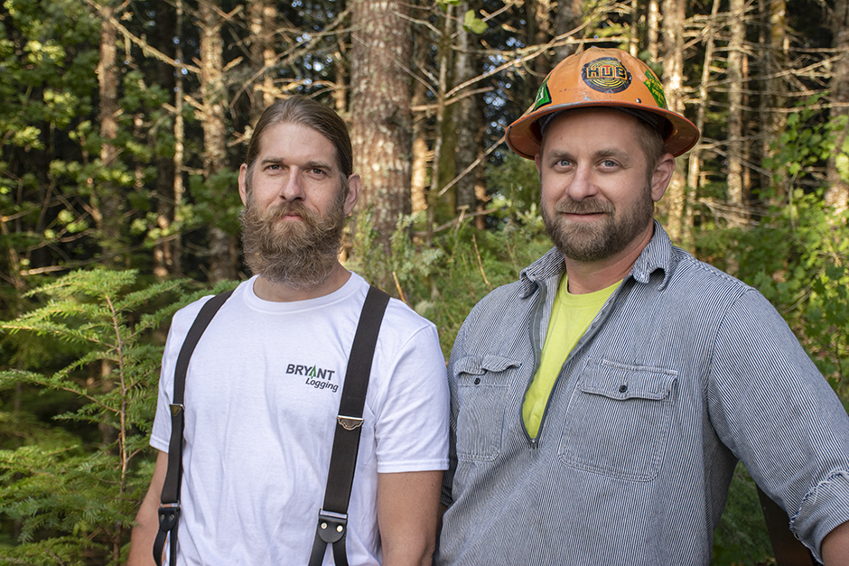 Dos hombres posan en el bosque.