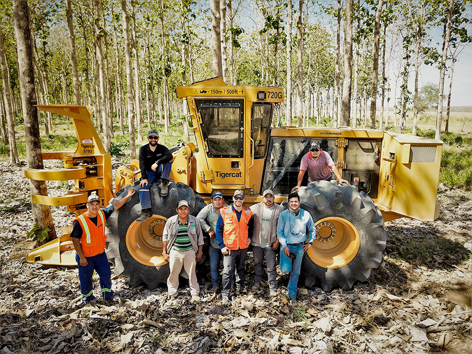 El equipo de cosecha y personal de Latin Equipment Norte delante del feller buncher 718G.