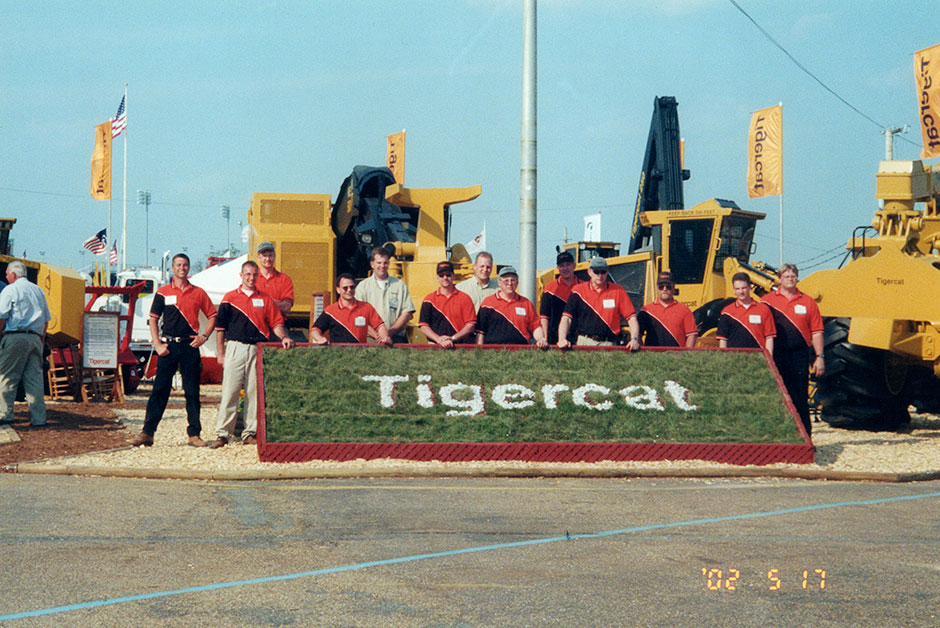 Arbetslaget på Tigercat-mässan i Richmond 2002 bär de ökända orange-svarta mäsströjorna. De blev kvar under flera år. (Dick är fjärde från höger)