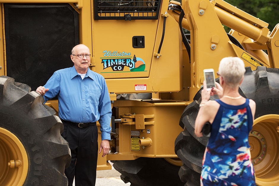 At Tigercat’s 25th anniversary celebration in 2017, Dick poses as his wife Janet snaps a picture of him in front of the very first Tigercat machine ever produced.