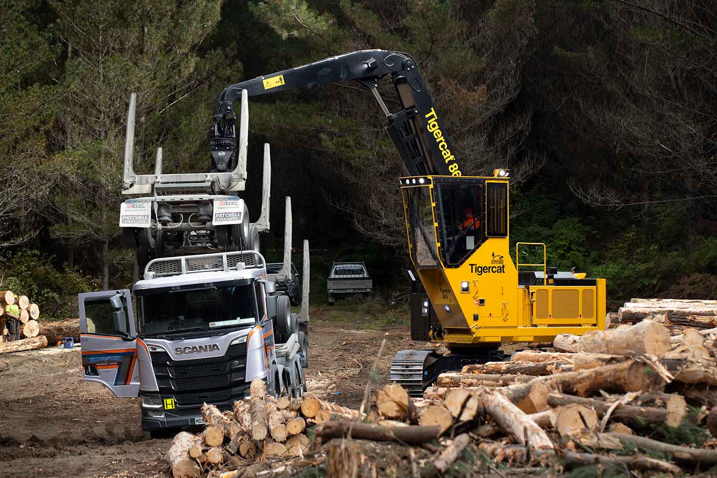 Une photo de la chargeuse 865 en train de soulever facilement une remorque de six tonnes.