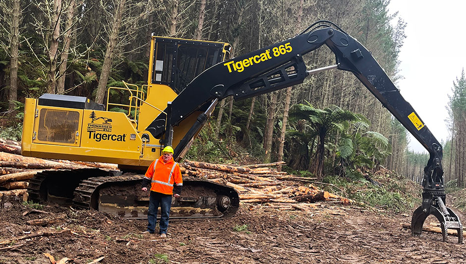 A picture of Ron Thomassen in front of the new 865 logger.