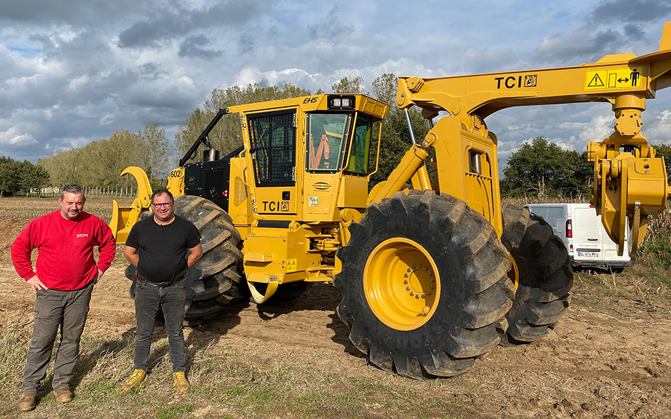 Una foto de Christophe y Denis posando delante del skidder 602.