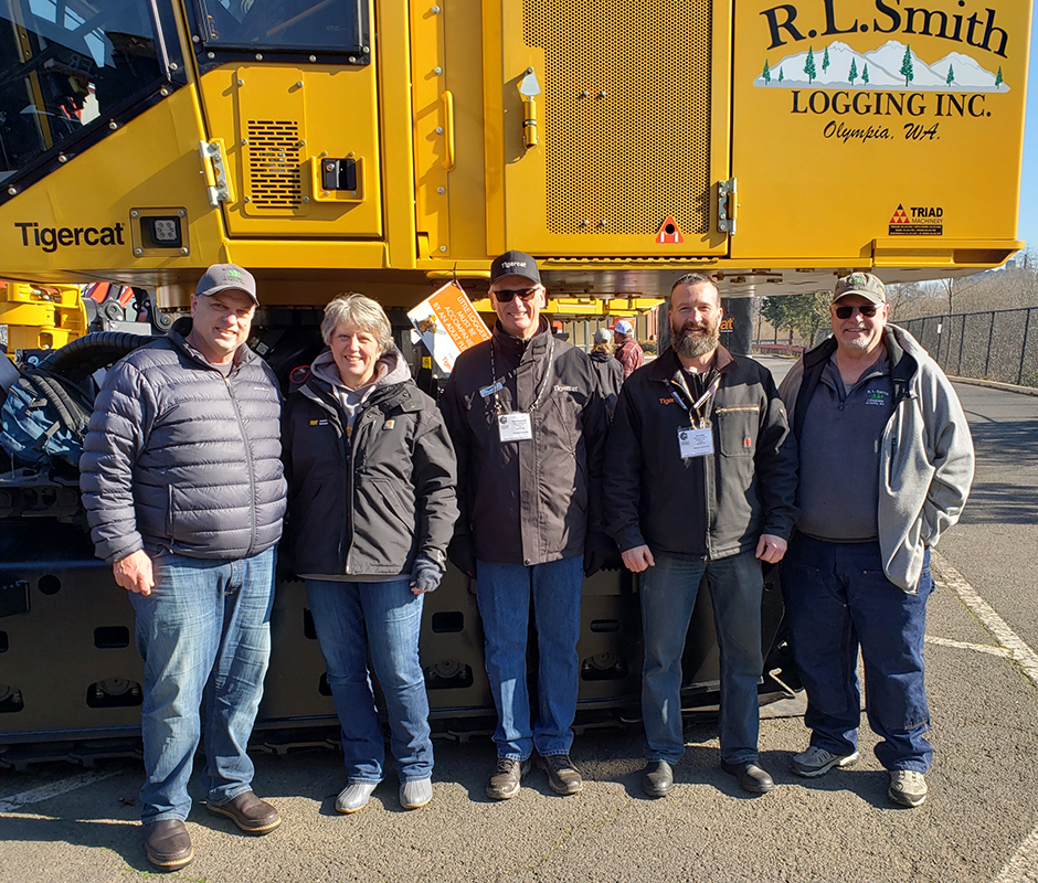 Long-time customers in front of their newest and twelfth Tigercat machine. (L-R) Roger and Carmen Smith (owners of R.L. Smith Logging), Grant Somerville and Rob Selby (Tigercat), and veteran R.L. Smith operator, Gary Smith.