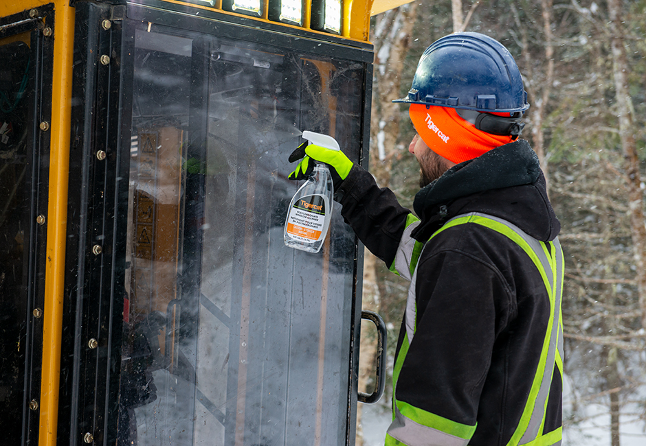 Opérateur nettoyant la vitre d’une cabine Tigercat