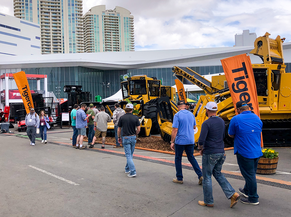 People walking past Tigercat equipment display at CONEXPO