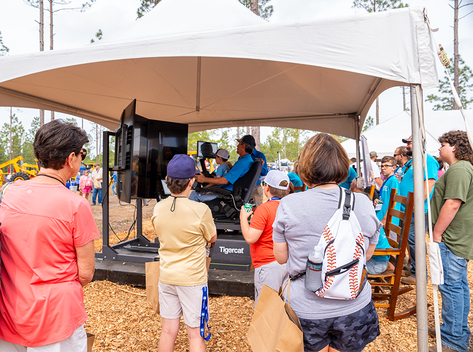 A group of people looking at a Tigercat simulator
