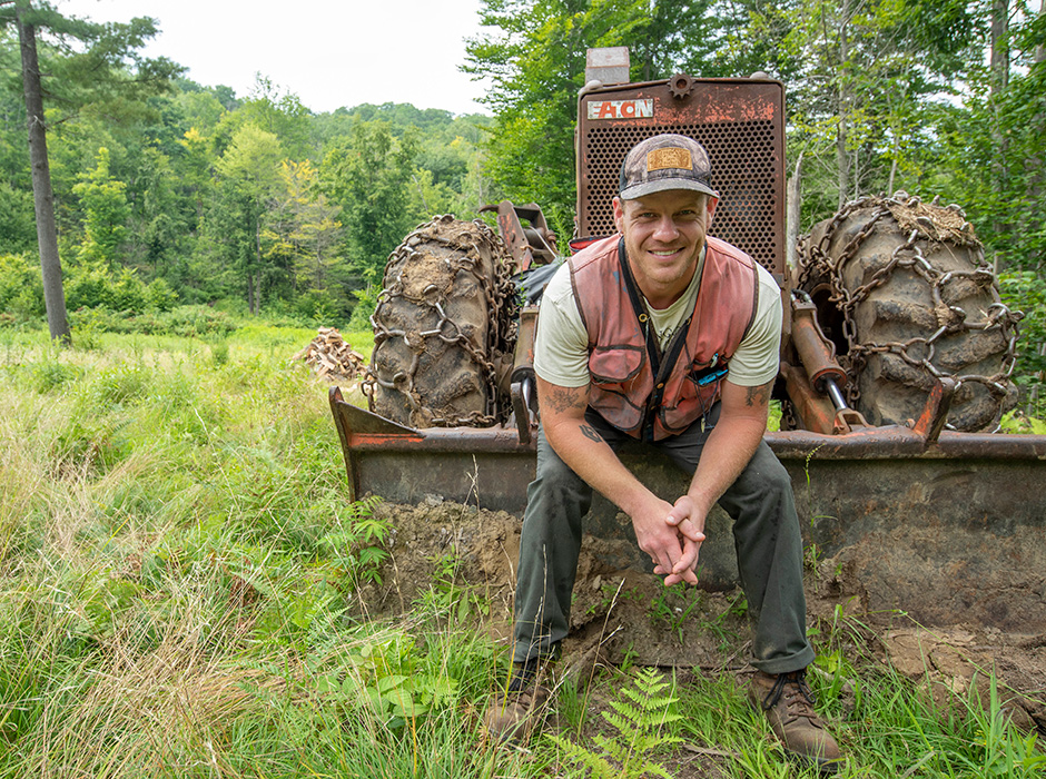 Ethan sitting on skidder blade