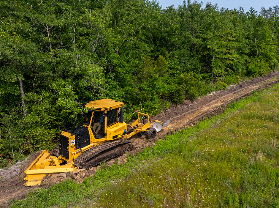 On the second pass, the V-blade clears any remaining debris, widens the break, and grades the surface to allow for vehicle access.